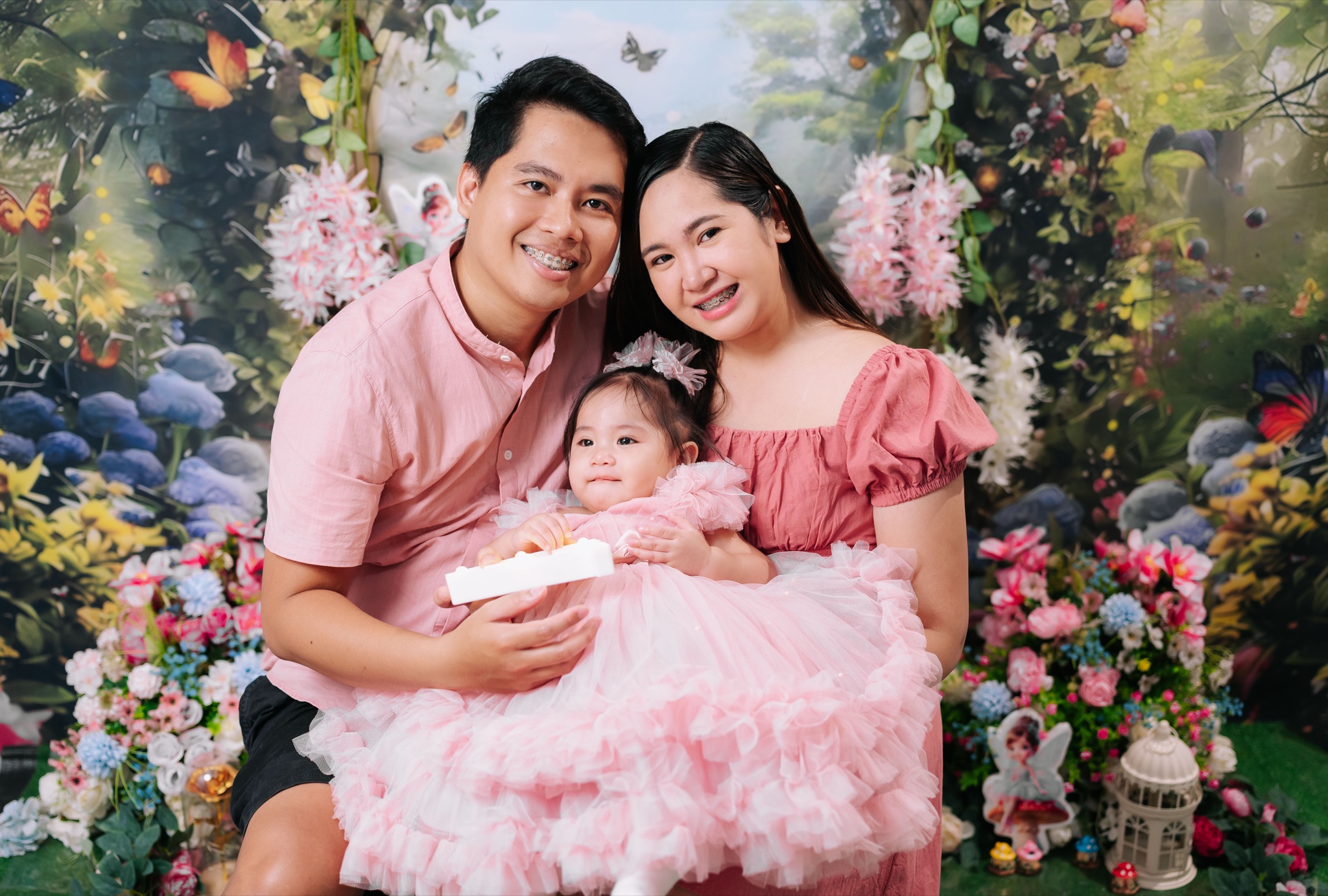 Amara with her parents in a fairy garden setting